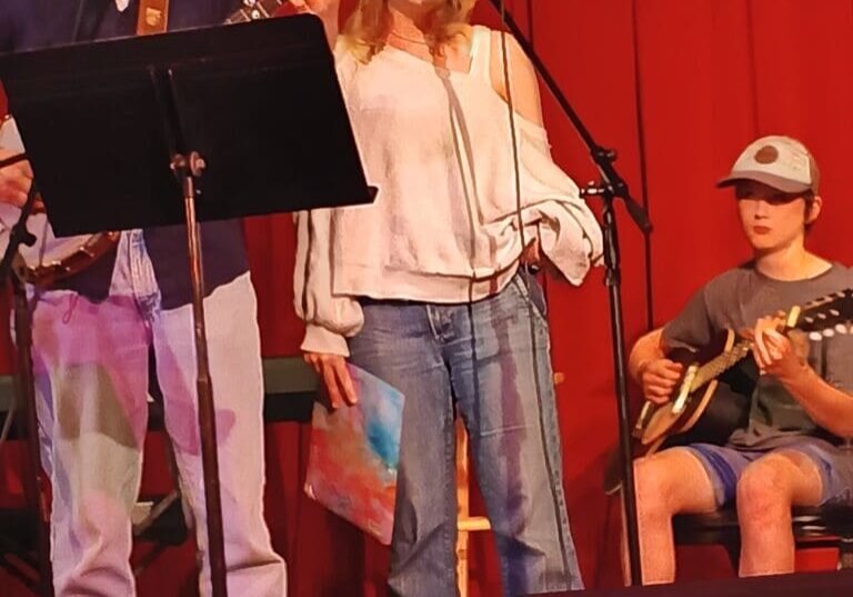 Three musicians performing on stage with instruments.