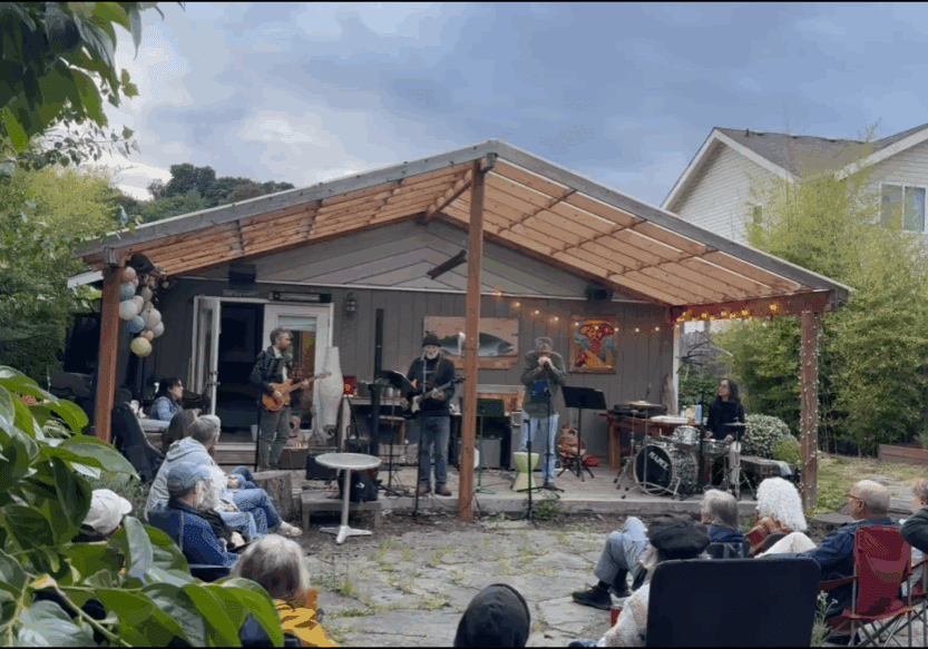 Backyard concert with band and audience outdoors.